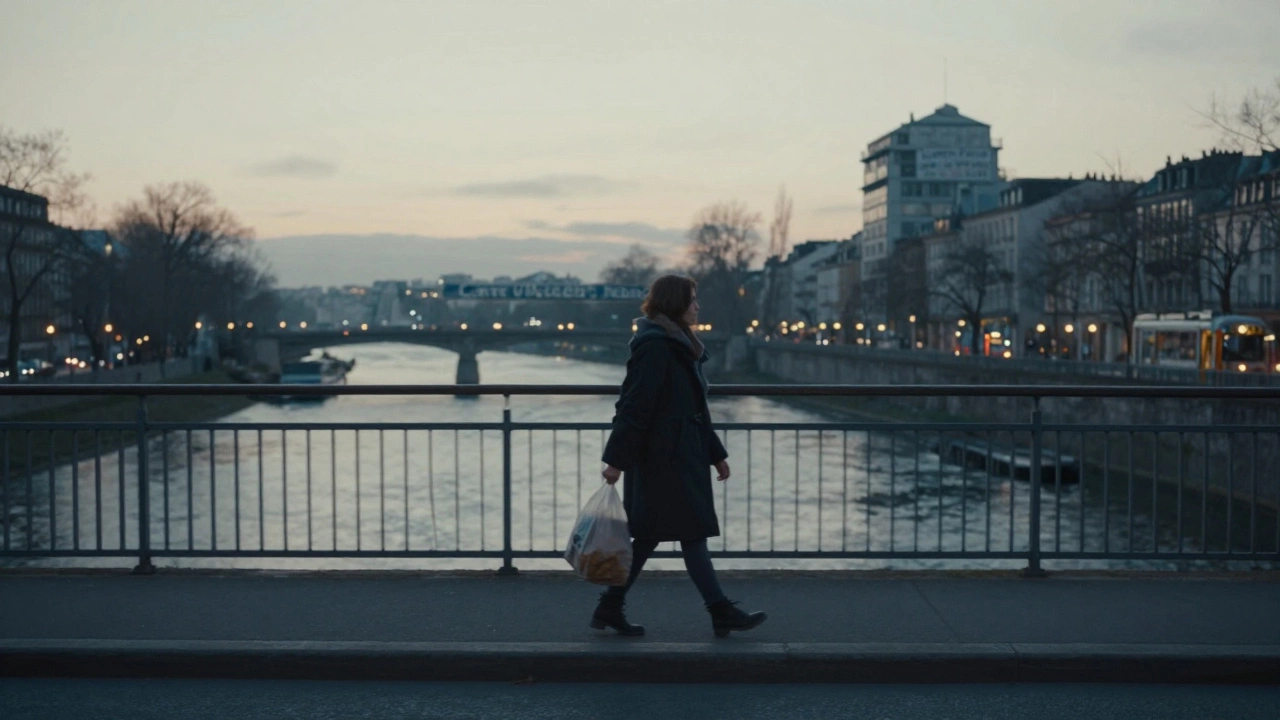 A woman walks across a bridge at dawn, carrying a grocery bag, city lights glowing faintly behind her.